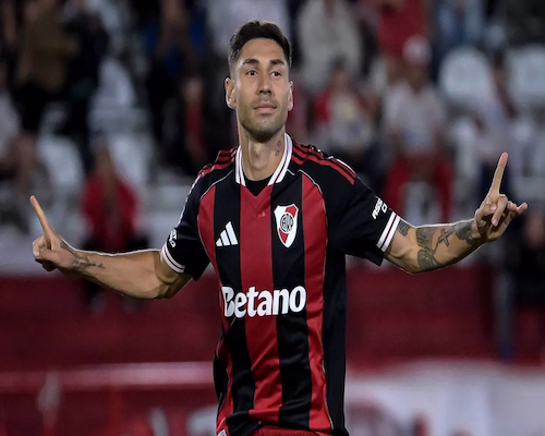 Gonzalo Montiel con camiseta negra y roja celebra un gol con los brazos extendidos durante un partido.