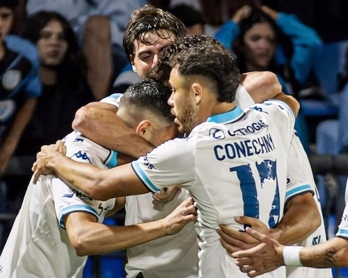 Jugadores de Racing Club celebran un gol abrazados durante el partido ante Belgrano