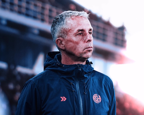 Gustavo Álvarez, nuevo DT de San Lorenzo, con campera institucional observando el campo de juego