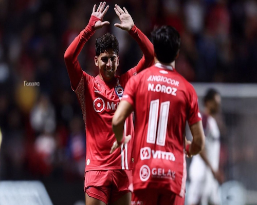 Jugador de Argentinos Juniors festeja un gol con Nicolás Oroz durante el partido ante Lanús