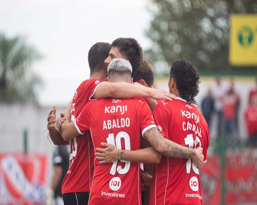Jugadores de Independiente festejan un gol abrazados durante el partido ante Sportivo Atenas