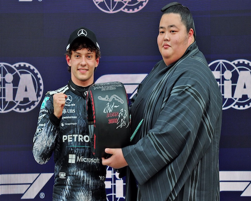 Kimi Antonelli posa con el trofeo de la pole position del Gran Premio de Japón junto a un luchador de sumo tras la clasificación en Suzuka