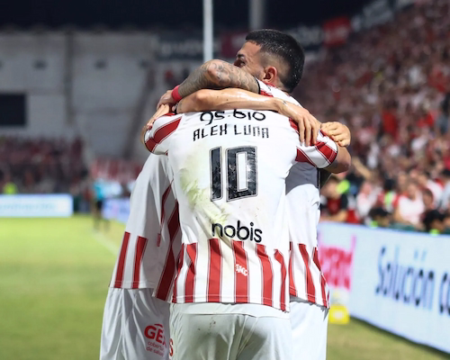 Alex Luna celebra su gol con sus compañeros de Instituto con un abrazo