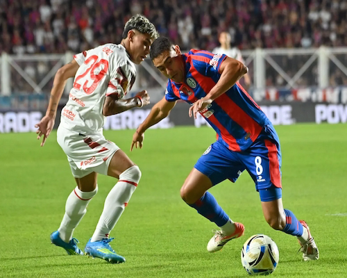 Carlos Insaurralde controla la pelota ante la marca de un jugador de Estudiantes durante el partido