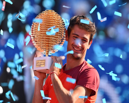Mariano Navone sonríe mientras sostiene el trofeo del ATP 250 de Bucarest bajo una lluvia de papel picado
