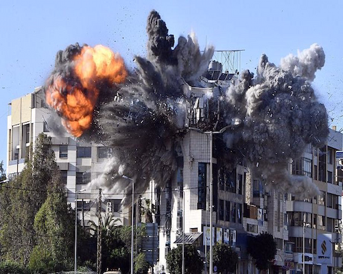 Explosión en un edificio durante un bombardeo en Líbano, con una gran bola de fuego y columnas de humo elevándose sobre la estructura