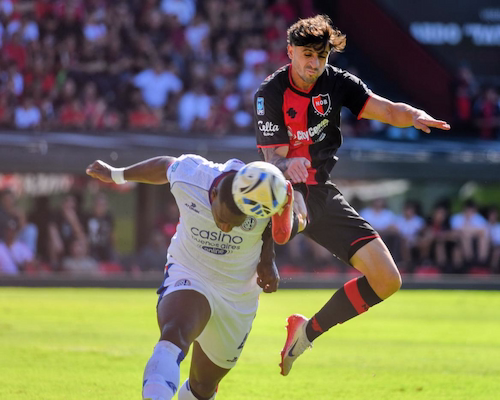 Jugador de Newell’s Old Boys y futbolista de San Lorenzo disputan una pelota aérea durante el partido