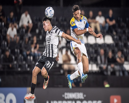Jugador de Libertad y jugador de Rosario Central disputan una pelota aérea durante el partido de Copa Libertadores
