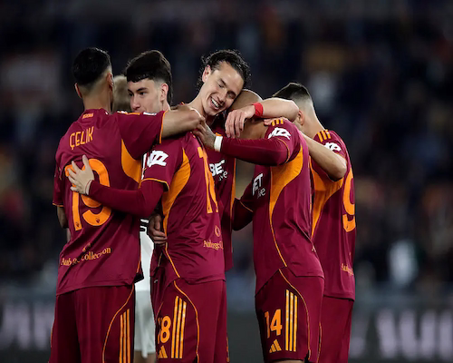 Jugadores de la Roma celebran un gol abrazándose en el campo de juego