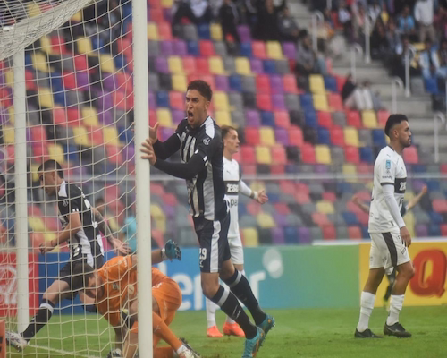 Jugador de Central Córdoba celebra un gol junto al arco mientras el arquero rival queda en el suelo y futbolistas de Platense reaccionan.
