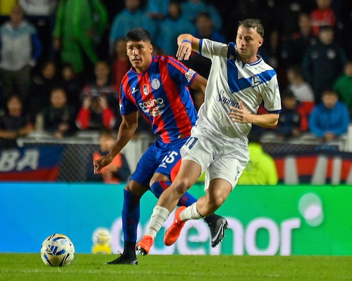 Jugador de San Lorenzo y jugador de Vélez disputan la pelota durante el partido del Torneo Apertura