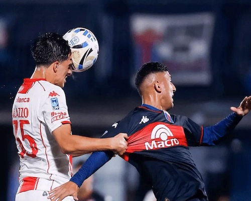 Máximo Palazzo cabecea el balón mientras disputa la jugada con un futbolista de Tigre