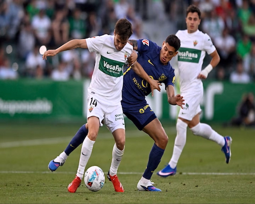 Nahuel Molina disputa la pelota con un jugador del Elche durante un partido de LaLiga