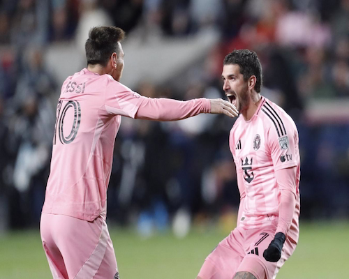 Lionel Messi de espaldas abre los brazos para abrazar a Rodrigo De Paul, que celebra con emoción