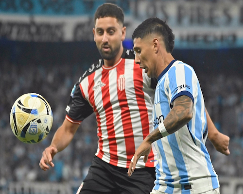 Jugador de Racing Club disputa el balón con un futbolista de Barracas Central durante el partido