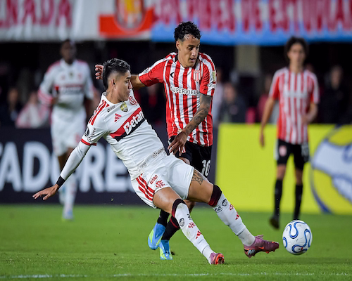 Tiago Palacios disputa la pelota con un jugador de Flamengo en un partido de la Copa Libertadores