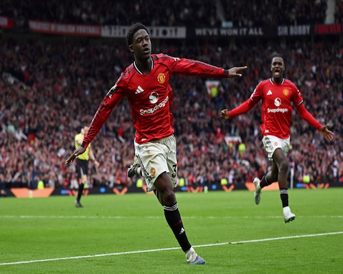 Kobbie Mainoo celebra su gol con los brazos abiertos durante el partido entre Manchester United y Liverpool