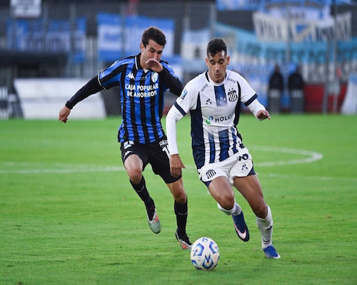 Un futbolista de Talleres avanza con el balón mientras un jugador de Atlético Tucumán lo persigue en los dieciseisavos de final de la Copa Argentina