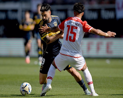 Milton Giménez y Arzamendia se disputan la pelota durante el partido en La Plata.