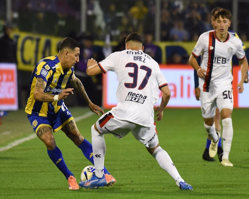 Ángel Di María conduce la pelota e intenta eludir a un defensor de San Lorenzo durante el partido en el Gigante de Arroyito.