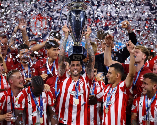 Jugadores de Estudiantes celebran levantando el Trofeo de Campeones en medio de una lluvia de papelitos tras la final.