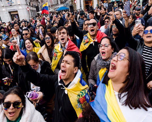 Multitud de manifestantes en una avenida principal de Caracas con banderas venezolanas.