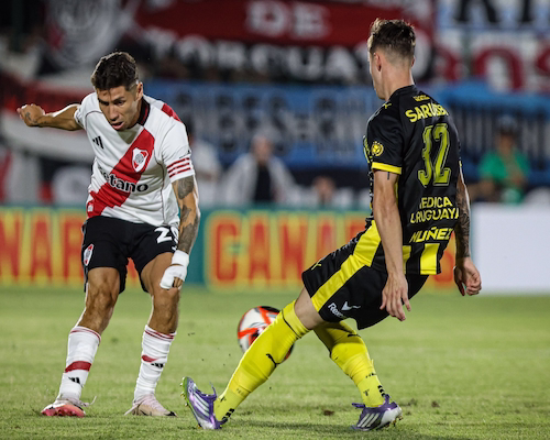 Jugador de River Plate controla la pelota ante la marca de un futbolista de Peñarol durante el amistoso por la Serie Río de la Plata.