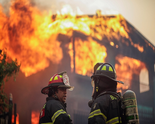 Bomberos combaten un incendio que consume una vivienda durante la emergencia forestal en Chile