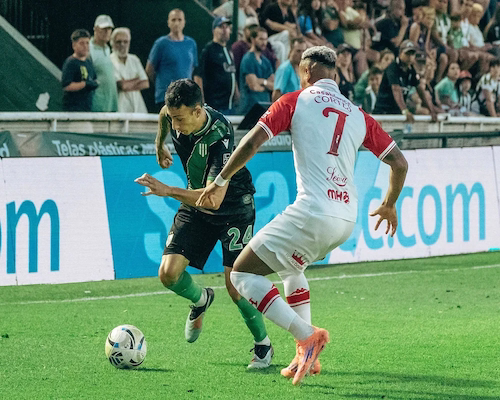 Jugador de Banfield intenta desbordar por la banda mientras es marcado por un futbolista de Huracán durante el partido en el Florencio Sola