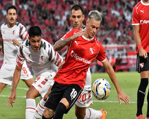 Jugador de Independiente controla la pelota ante la presión de futbolistas de Estudiantes durante el partido en Avellaneda.