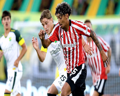 Cristian Medina avanza con la pelota ante la marca de un jugador de Defensa y Justicia durante el partido por la Liga Profesional.
