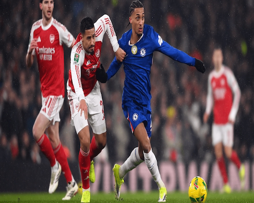 Jugador de Chelsea y jugador de Arsenal luchan por la posesión del balón durante la semifinal de la EFL Cup.