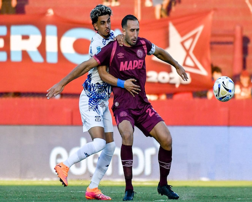 Carlos Izquierdoz protege la pelota ante la marca de un futbolista de Talleres de Córdoba durante el partido por la Liga Profesional.