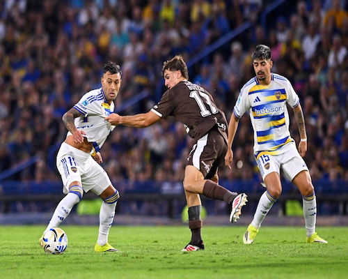 Jugador de Boca Juniors intenta avanzar con la pelota ante la marca de un futbolista de Platense en La Bombonera
