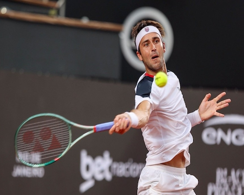 Tomás Etcheverry impacta la pelota con su raqueta durante un partido del Rio Open sobre polvo de ladrillo.