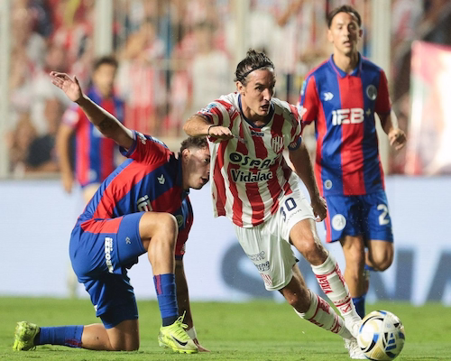 Jugador de San Lorenzo disputa la pelota con un futbolista de Instituto durante el partido por el Torneo Apertura.