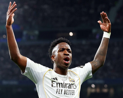 Vinícius Júnior levanta los brazos y alienta a la hinchada del Real Madrid tras convertir el gol del triunfo ante Benfica por la Champions League