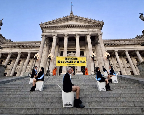 Activistas de Greenpeace realizan una protesta frente al Congreso con un cartel que dice “Senadores: no se caguen en el agua” en reclamo por la Ley de Glaciares.
