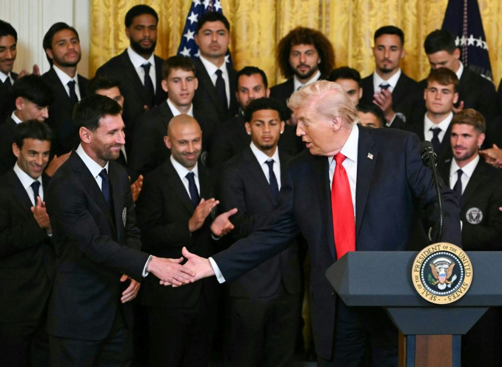 Donald Trump estrecha la mano de Lionel Messi mientras jugadores del Inter Miami observan atentamente.