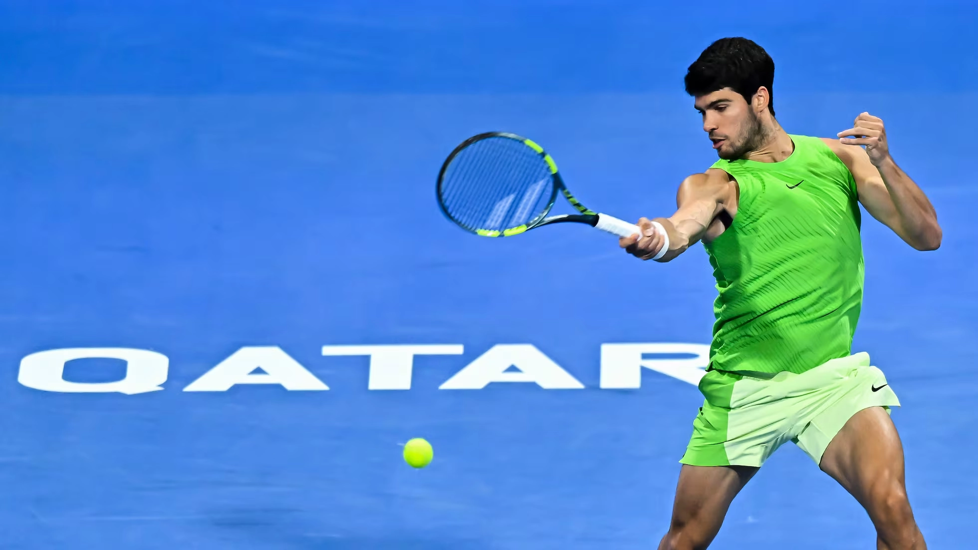 Carlos Alcaraz ejecuta un golpe de derecha durante un partido sobre cancha dura mientras la pelota se aproxima tras el rebote.