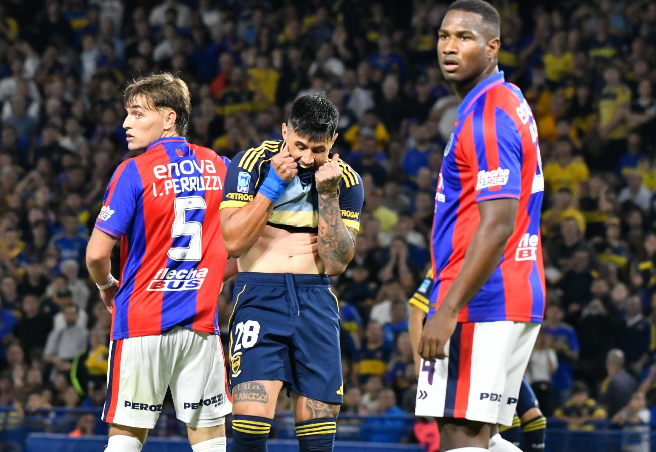 Adam Bareiro se lleva la camiseta a la boca mientras dos futbolistas de San Lorenzo lo observan durante el partido en La Bombonera.
