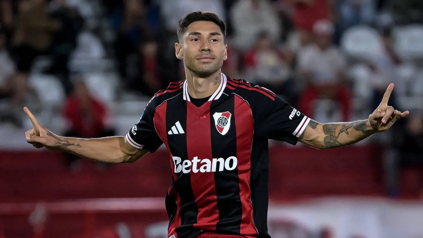 Gonzalo Montiel con camiseta negra y roja celebra un gol con los brazos extendidos durante un partido.