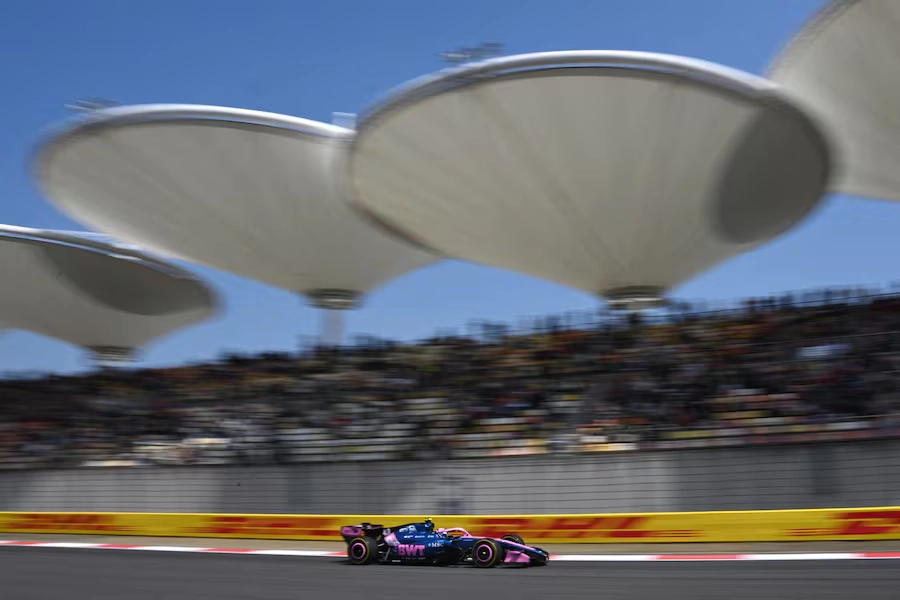 Monoplaza de Alpine durante una vuelta en pista en el circuito de Shanghái con las tribunas de fondo.