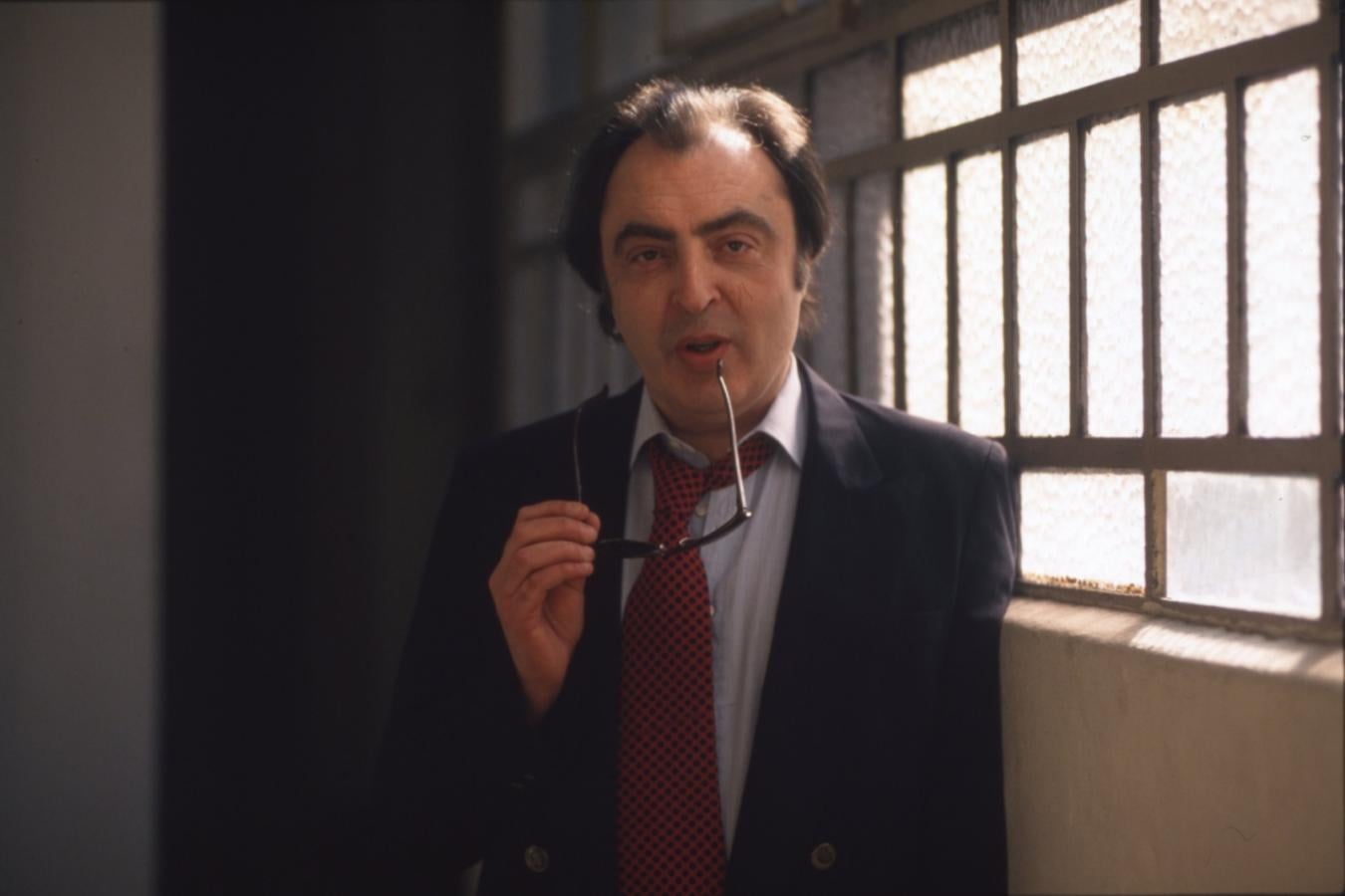 Marcelo Araujo de joven junto a una ventana mientras sostiene unos anteojos en su mano