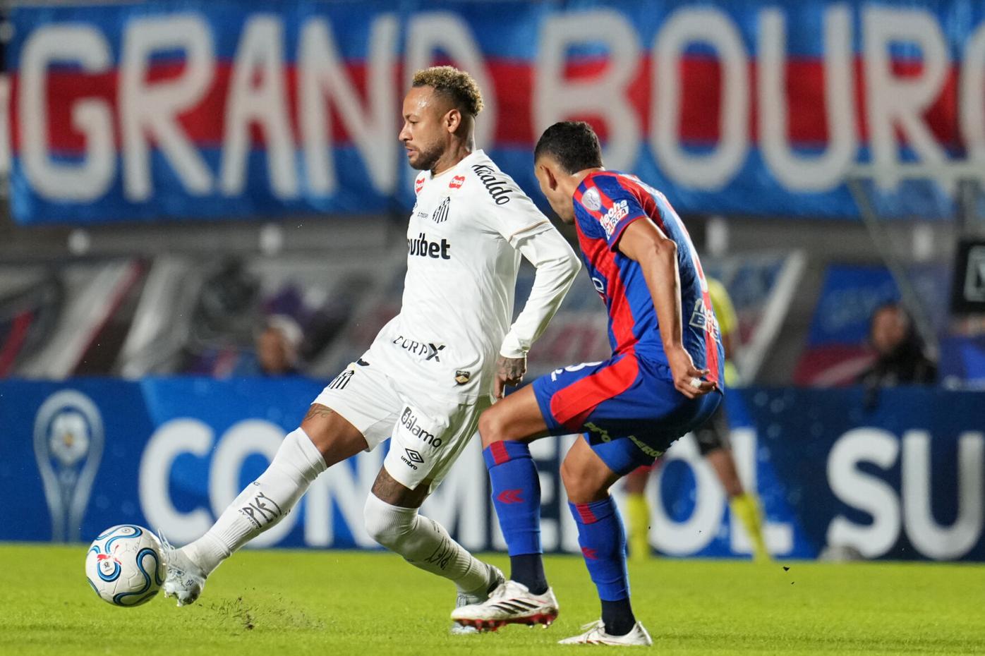 Neymar Jr. con la indumentaria del Santos FC ejecutando un pase frente a la marca de un jugador de San Lorenzo durante un partido de la Copa Sudamericana