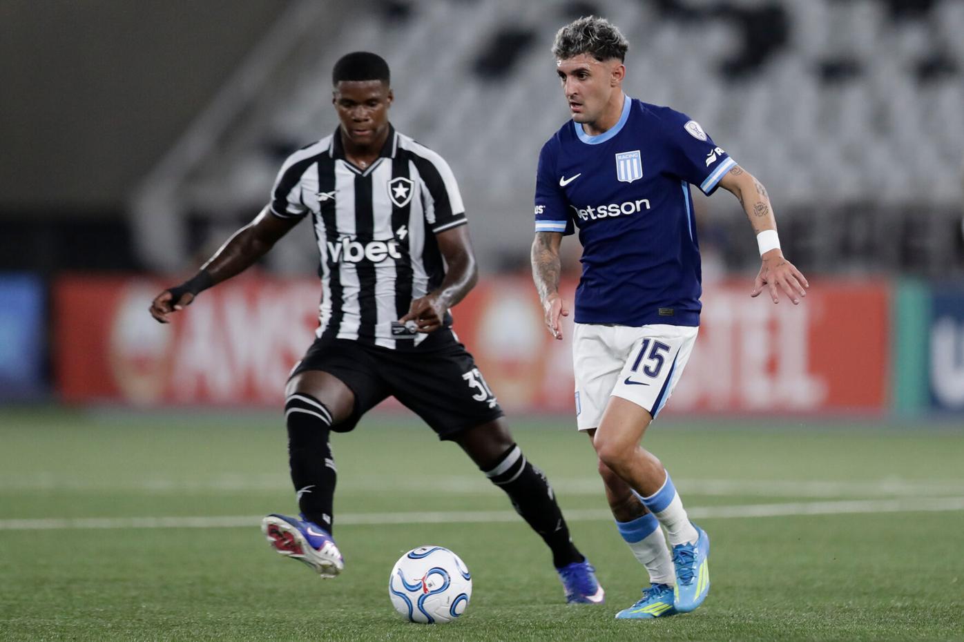 Gastón Martirena conduce la pelota mientras Kadir Barría lo presiona durante el partido entre Botafogo y Racing Club por la Copa Sudamericana 2026