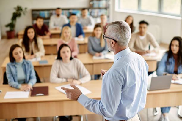 Docente universitario dando una clase frente a estudiantes en un aula