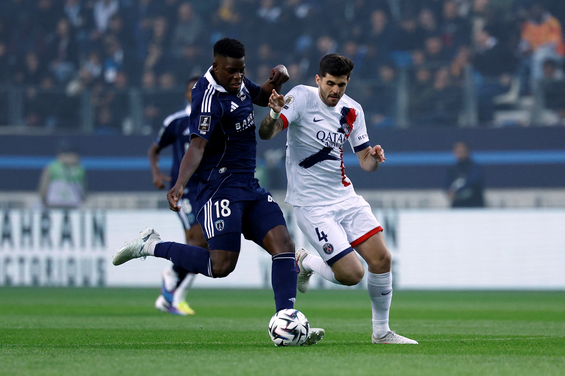 Un jugador de Paris FC disputa la pelota ante un futbolista de PSG durante el partido por la Ligue 1