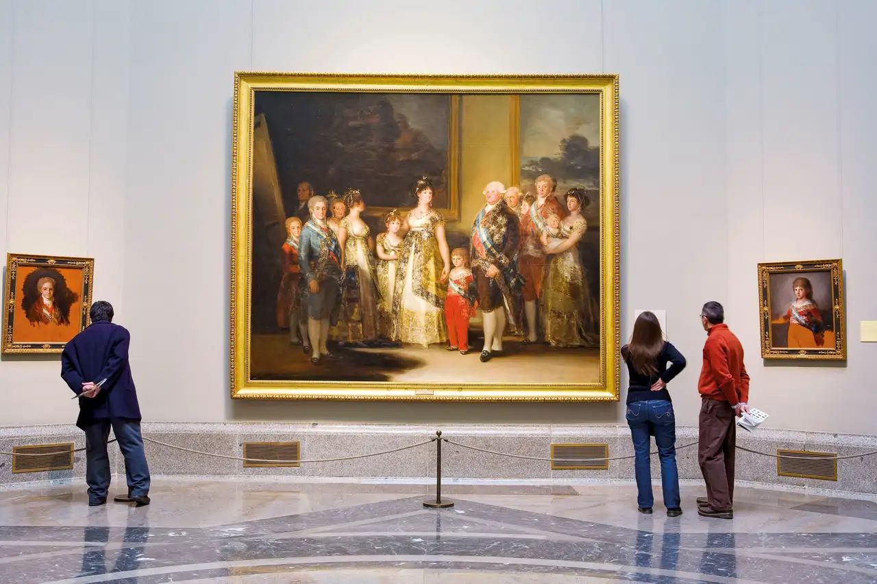 Visitantes observando la pintura “La familia de Carlos IV” de Francisco de Goya en el Museo del Prado.