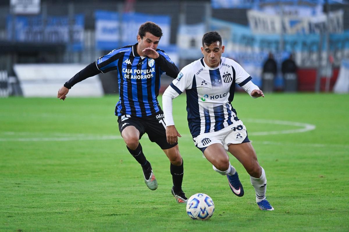Un futbolista de Talleres avanza con el balón mientras un jugador de Atlético Tucumán lo persigue en los dieciseisavos de final de la Copa Argentina